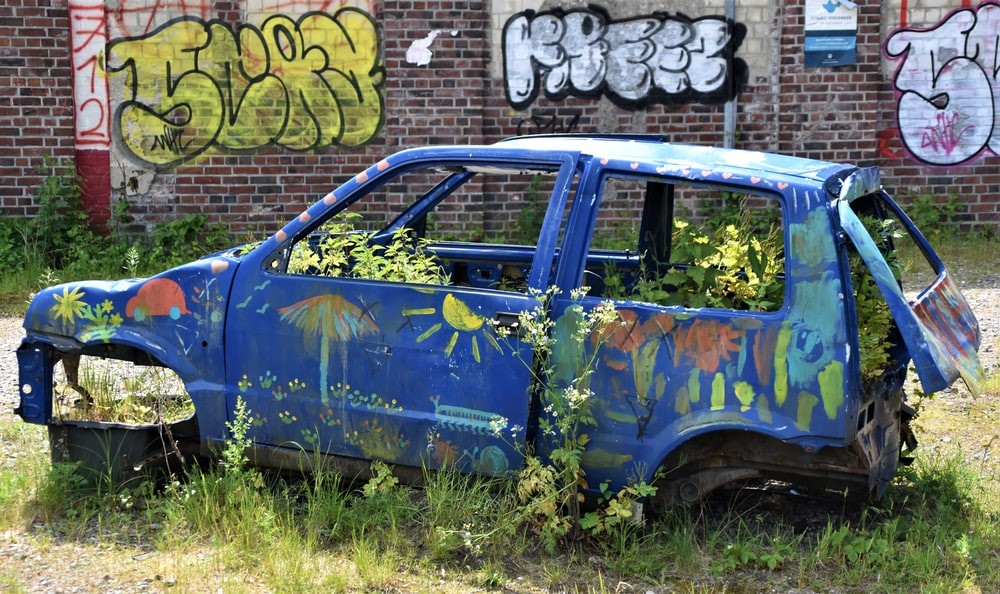 vandalized junk car leaves grass property