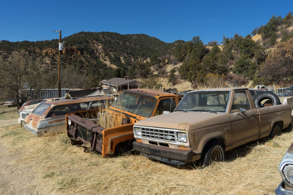 worn down junk cars parked in a scrap yard