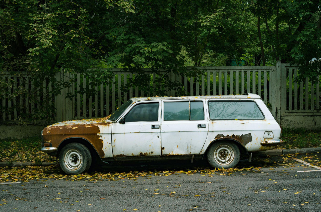 A junk car parked out of a house