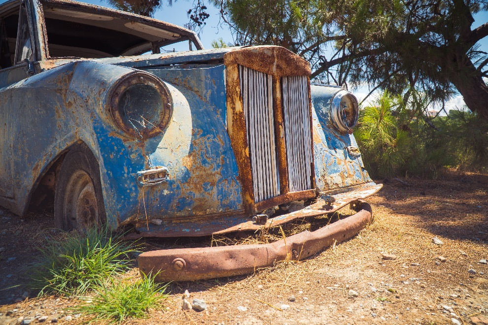 An old blue colored abandoned car