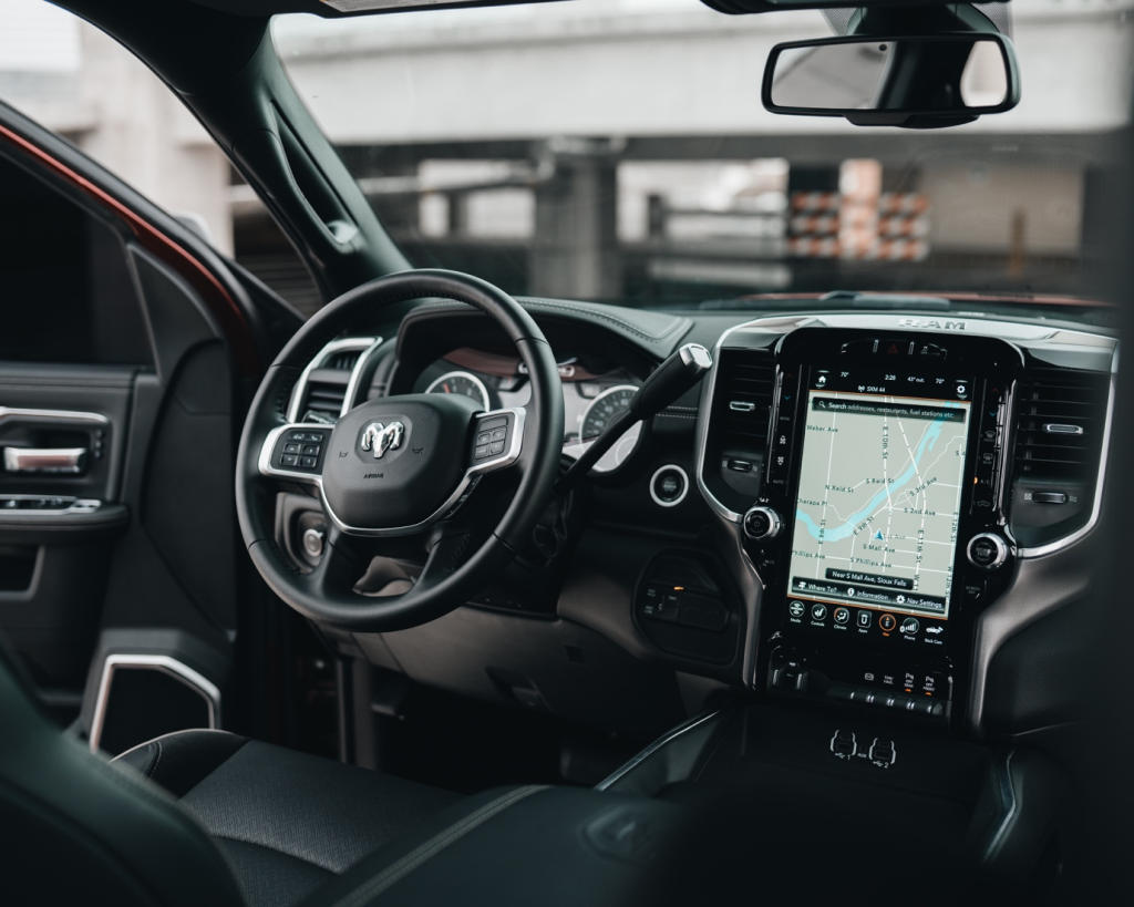 A person working on a laptop while sitting in a self-driving car