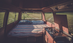 A photo showing a car interior with a bed.
