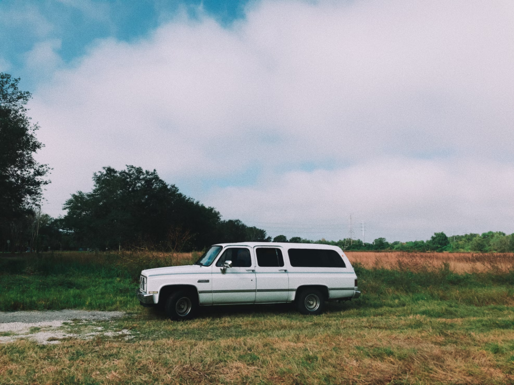A photo showing a car parked in a field.