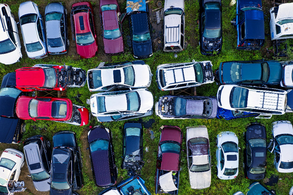 Numerous discarded cars piled up at a junkyard 
