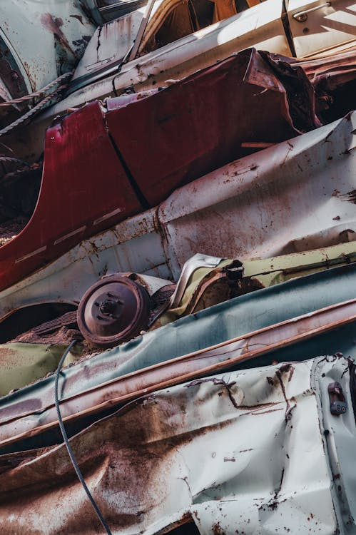 A wrecked car among a heap of metal scrap.