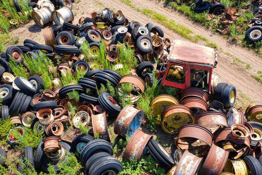 Aerial shot of rims and tires neatly arranged at a junkyard.