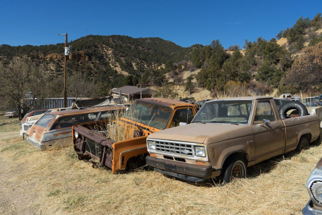 Abandoned pickup trucks in a junkyard awaiting removal.
