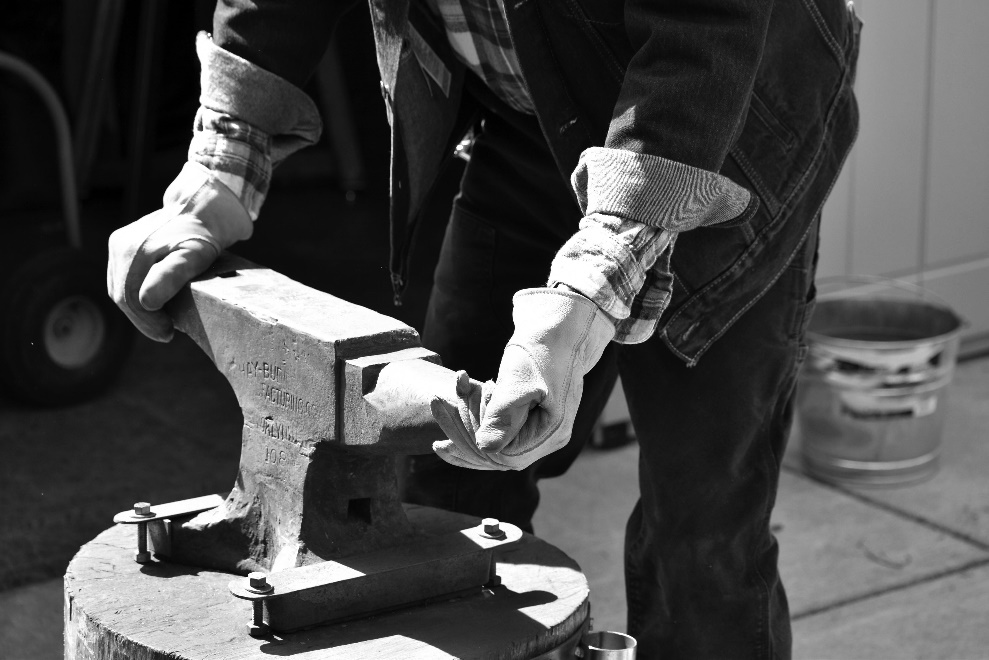 Black and white shot of a person holding the anvil 
