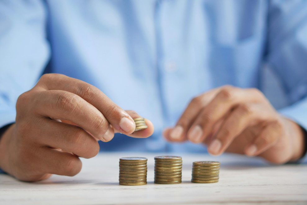 Person stacking coins on a surface 