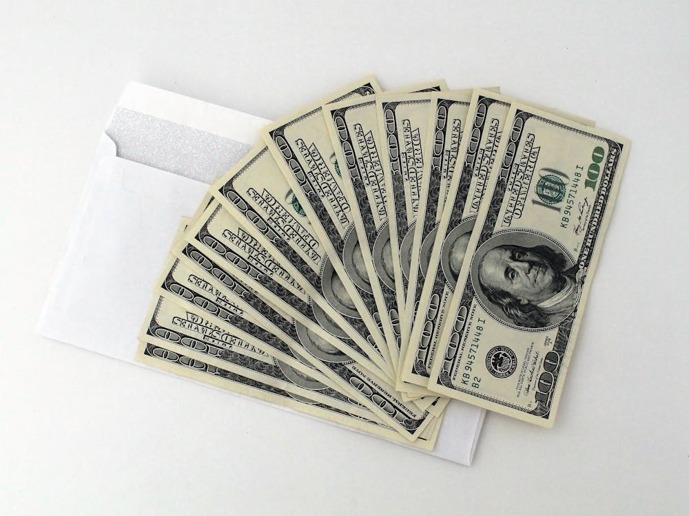 U.S. dollar banknotes on top of a white envelope