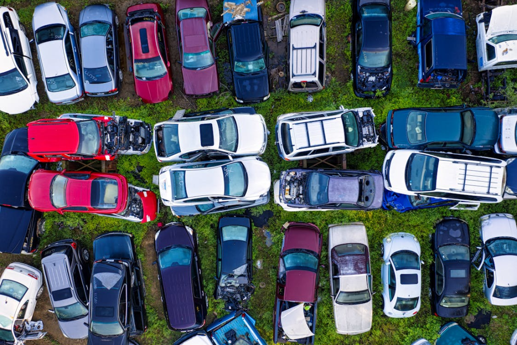 Aerial view of a junkyard of different colored cars.