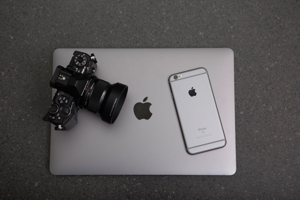 Professional camera and an iPhone on top of a MacBook